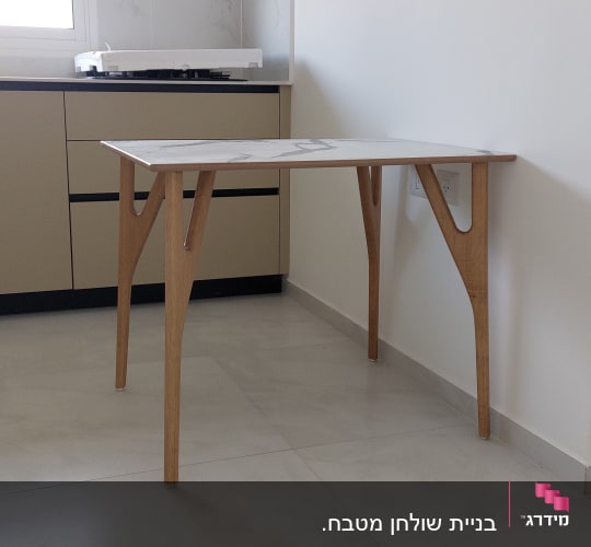 שולחן עץ עם רגליים מעוצבות בפינת חדר